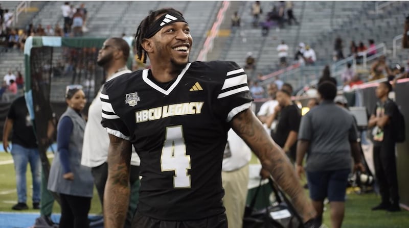 De'Jahn Warren walking along the field in his black jersey.