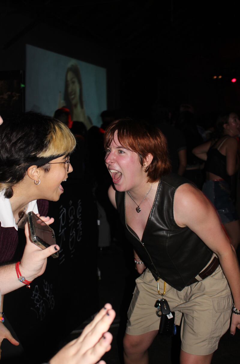 A fan screams with their mouth open wide.