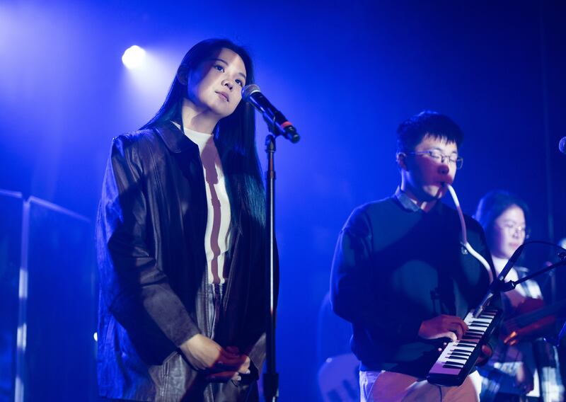 Photo of a woman next to a man with a keytar on a stage