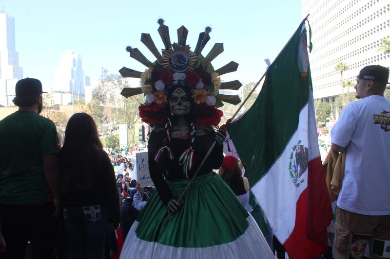 A catrina posing with a Mexican flag