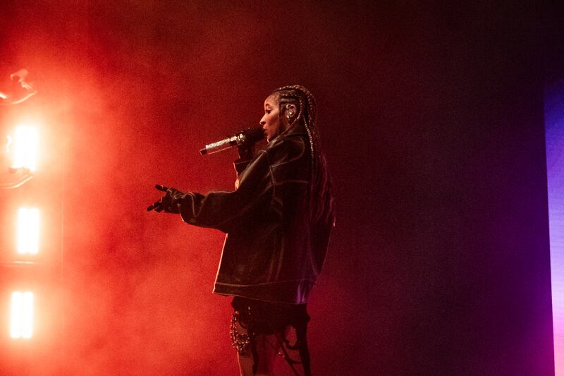 Photo of a woman singing in front of red lights