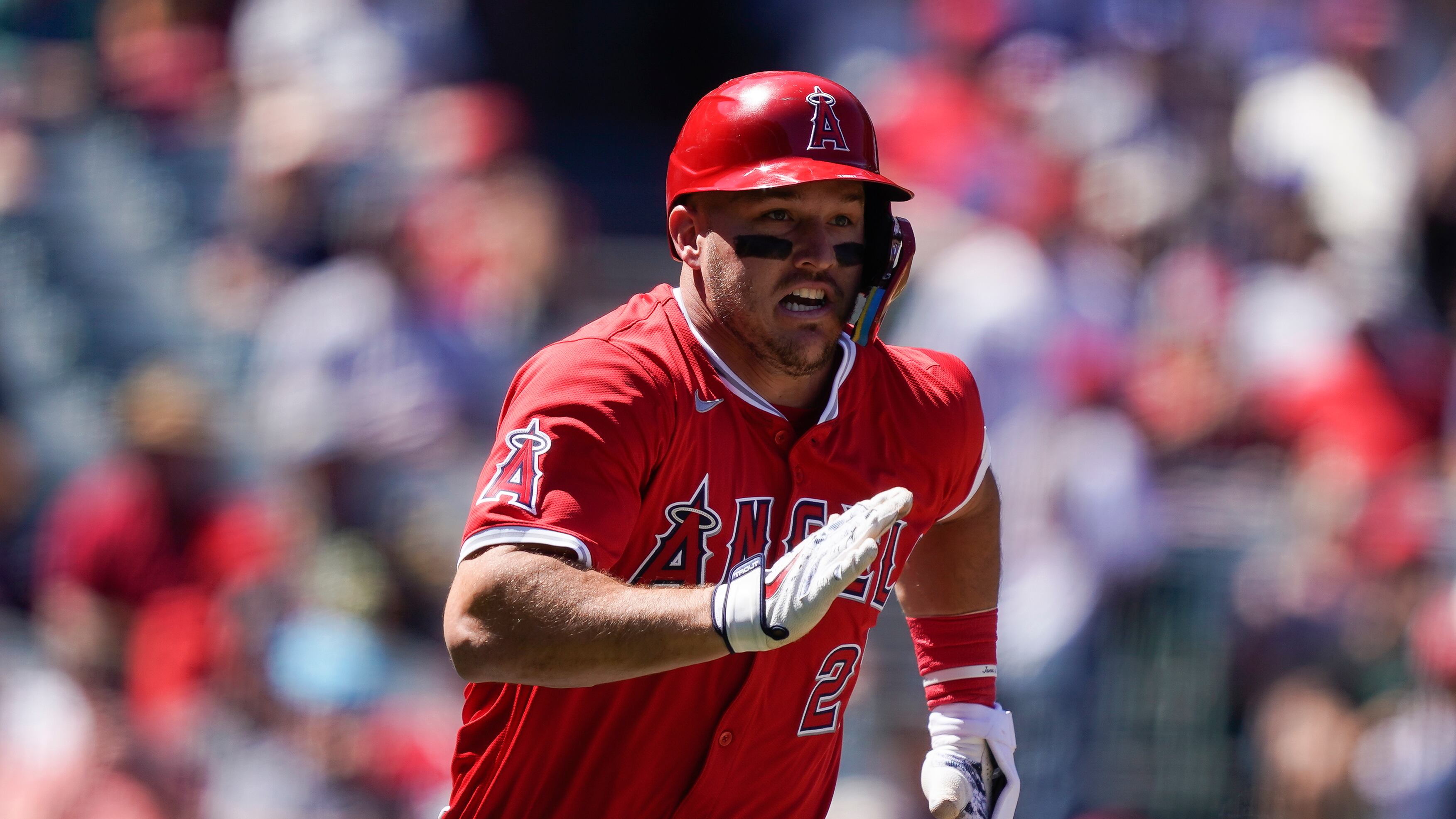 Los Angeles Angels designated hitter Mike Trout, wearing a red jersey and helmet, runs after hitting a double during the third inning of a baseball game against the Tampa Bay Rays, Wednesday, April 10, 2024, in Anaheim, Calif. (AP/Ryan Sun)