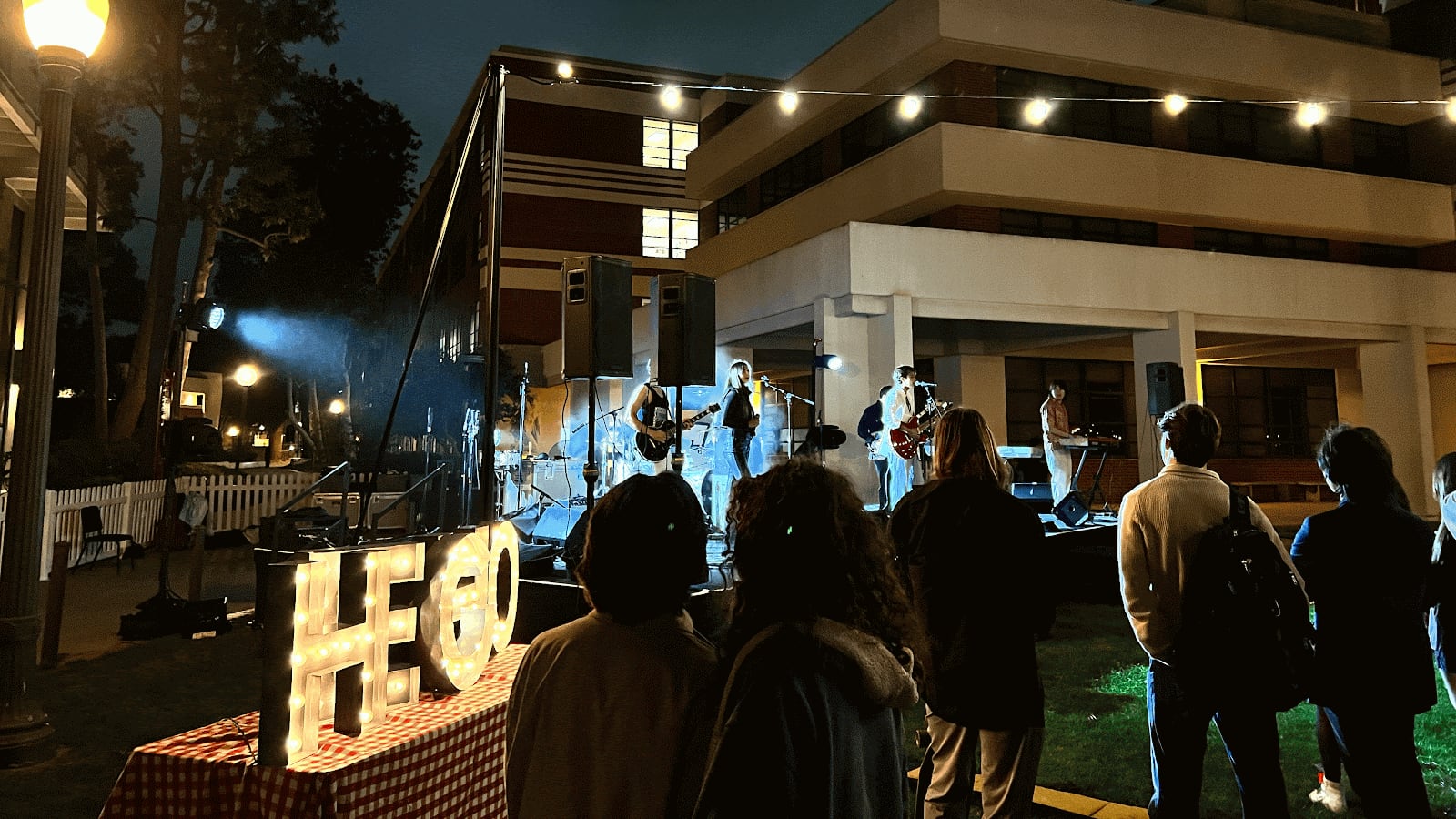 Photo of a singer performing on stage with people in watching.