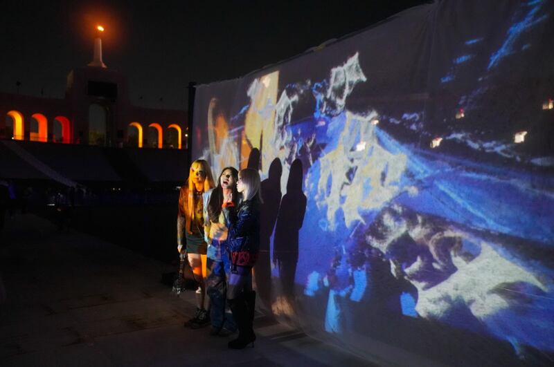 Students pose in front of student-made projections inspired by Don Toliver. (Photo by Kathryn Luo)