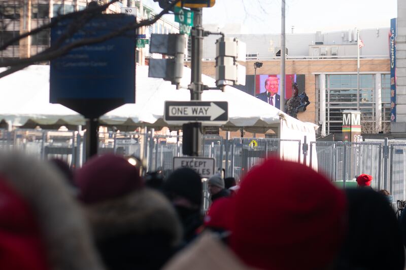 A picture of a video screen with Trump's face on the outside of a building.