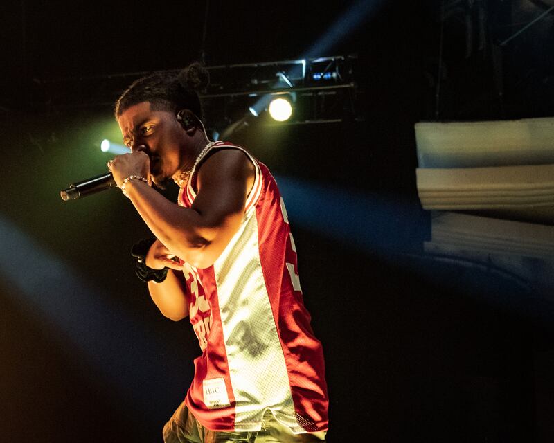 Photo of Smino rapping into the microphone on stage.