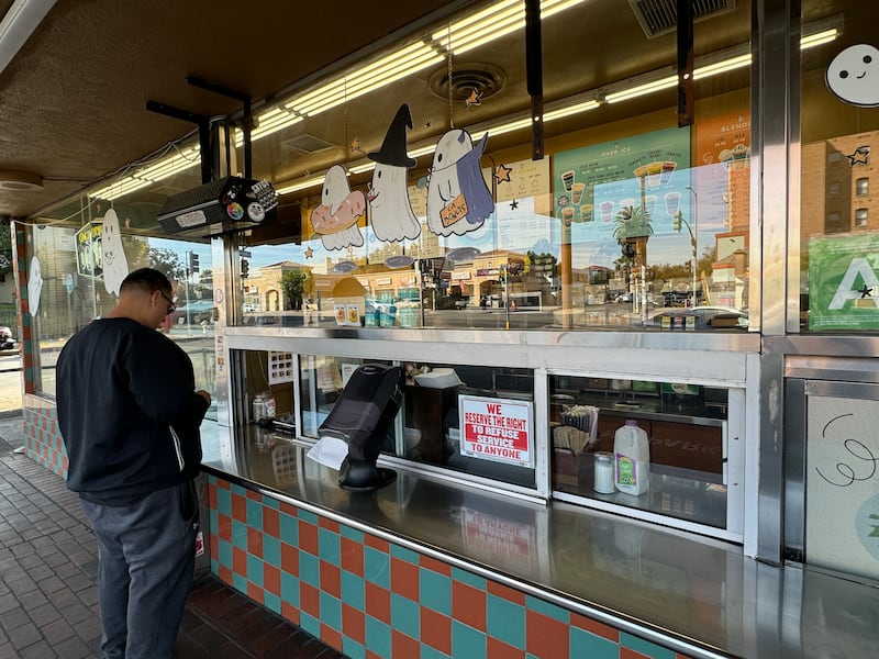 Photo of a man standing in front of a window making an order