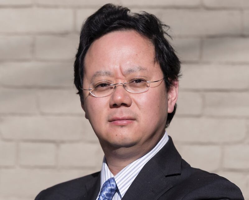 Photo of a man with glasses and a suit and tie