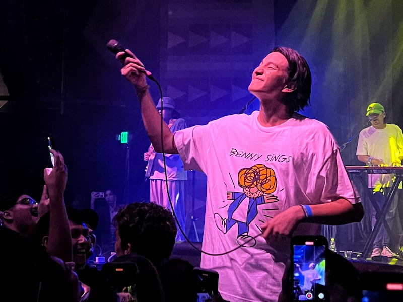 Photo of a man holding out a microphone