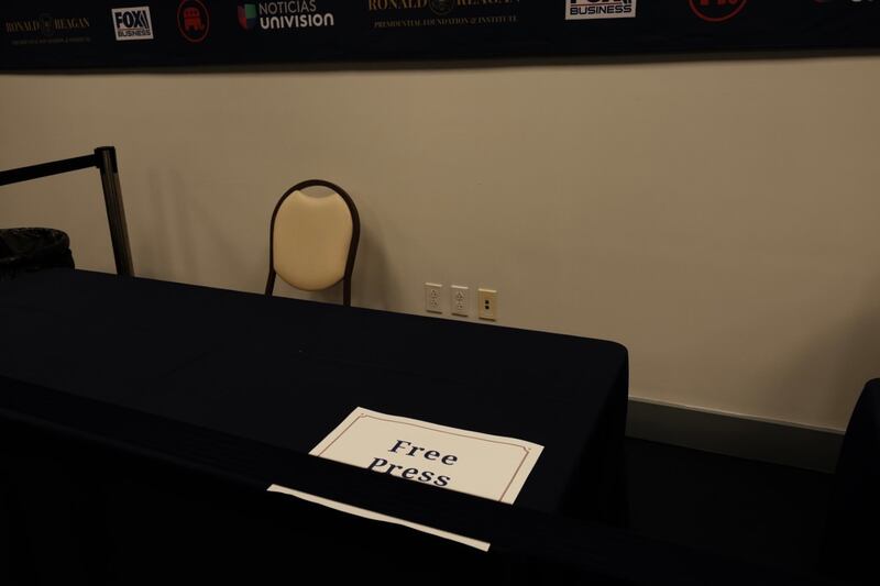 A sign for “Free Press” sits on an empty table.