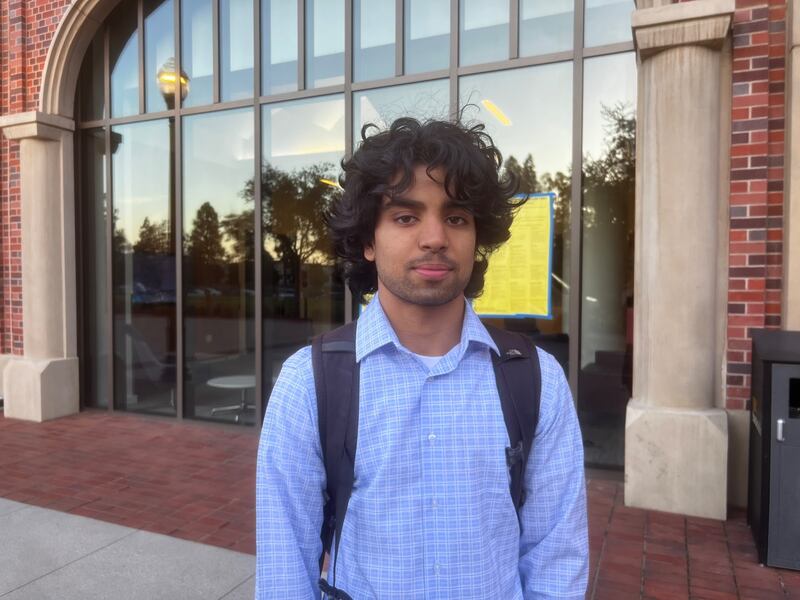 Godage standing in front of a glass and brick building.