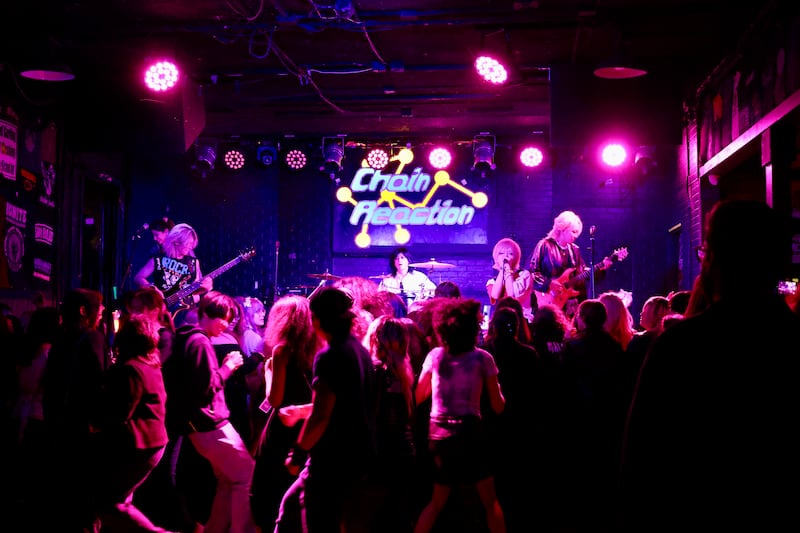 Pink lights beam down on a stage