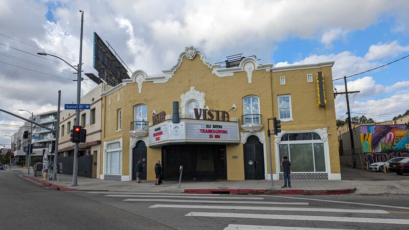 Photo of an old, yellow theater with a large sign that says "VISTA"