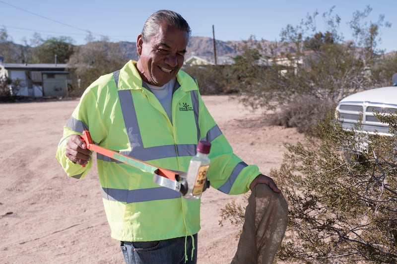 Fort Diaz, a local volunteer who lives 3 miles outside of the national park, picks up an empty bottle. He shares that he comes to Joshua Tree and the national park every two weeks to pick up trash to keep his community clean. “It’s like keeping your own home clean. This trash affects the local community so I see it as my responsibility to clean it up,” Diaz said. (Photo by Michael Chow)