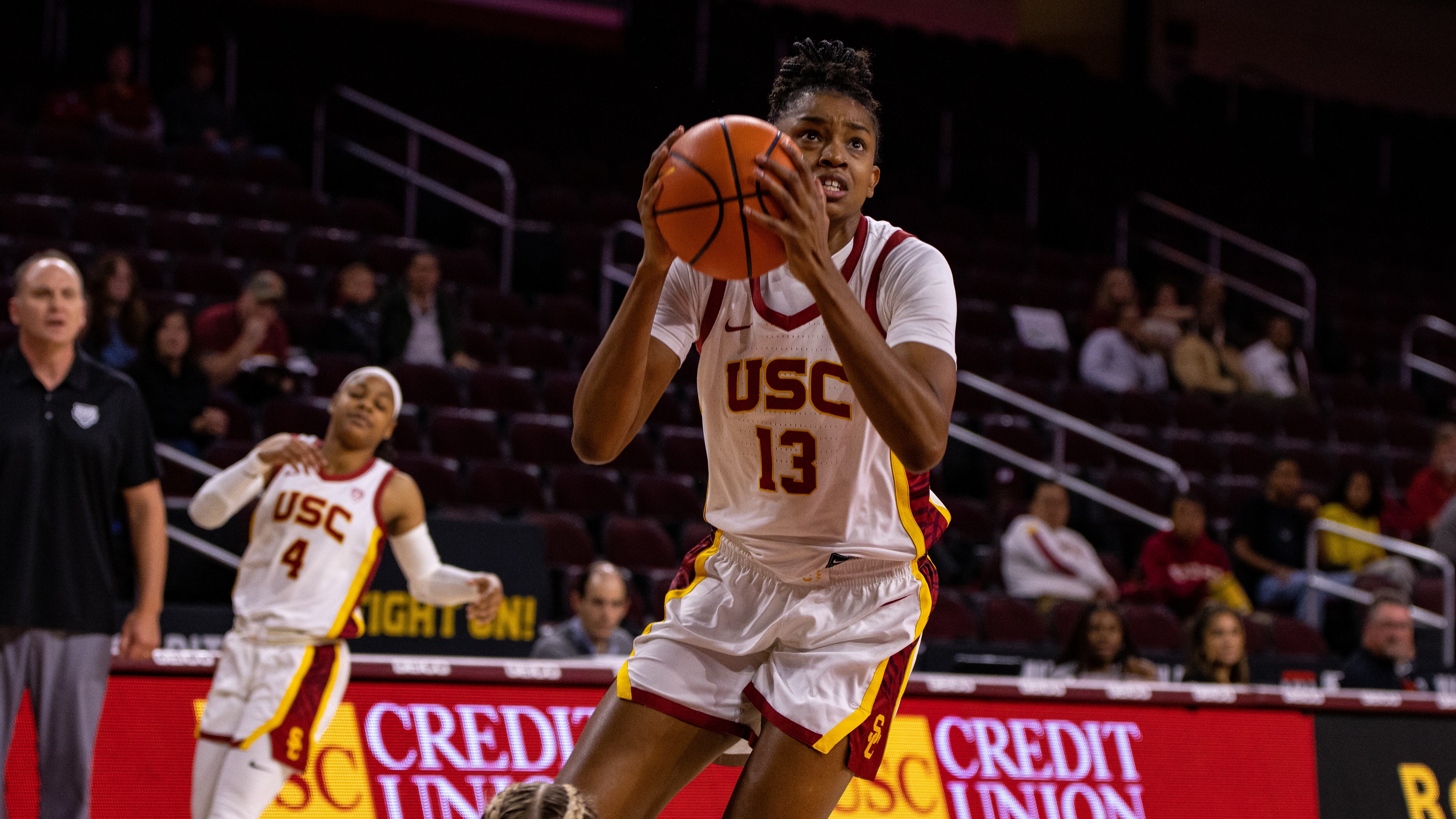 Rayah Marshall has the basketball collected in her hands. She is wearing an all-white uniform.
