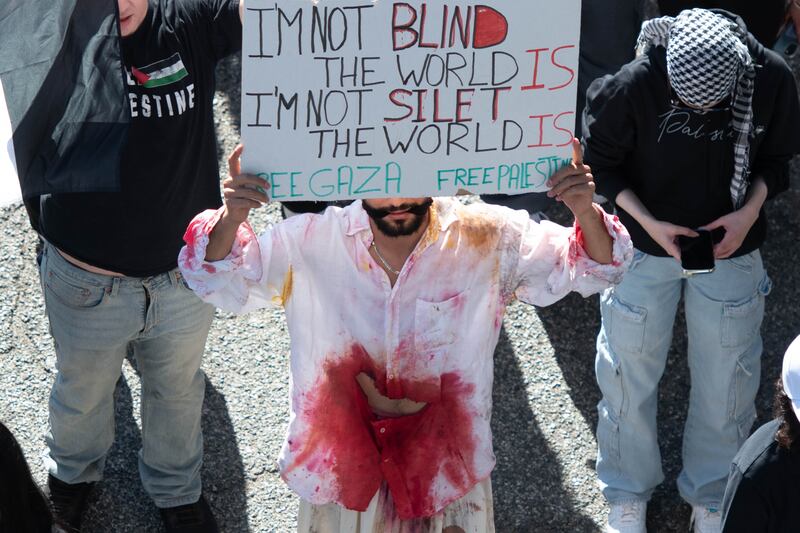 A protester at the “All Out For Gaza” Rally wears an outfit he made which references his mother's suffering and similar situation.
