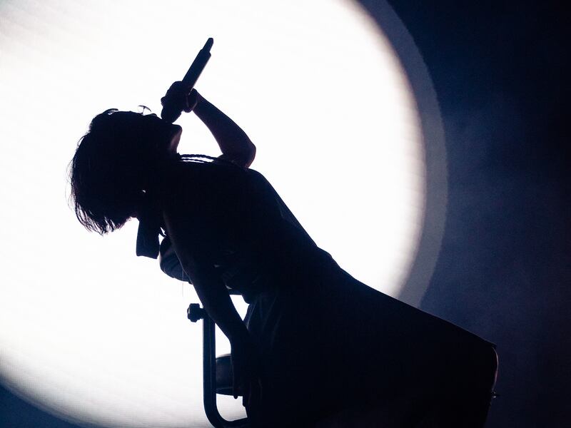 Photo of a woman in front of a spotlight leaning back on a rolling chair