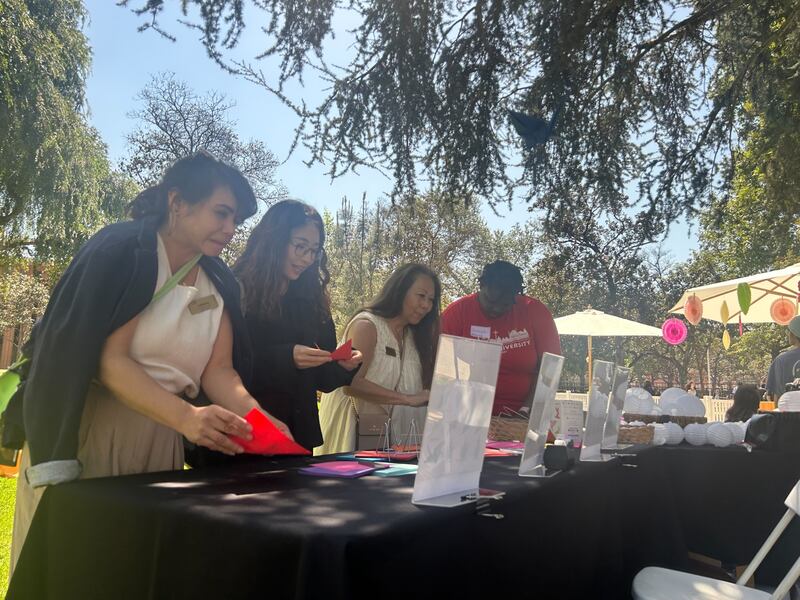 Parents, alumni, and students alike participate in folding origami cranes. (Photo by Michael Jiaming Liu)