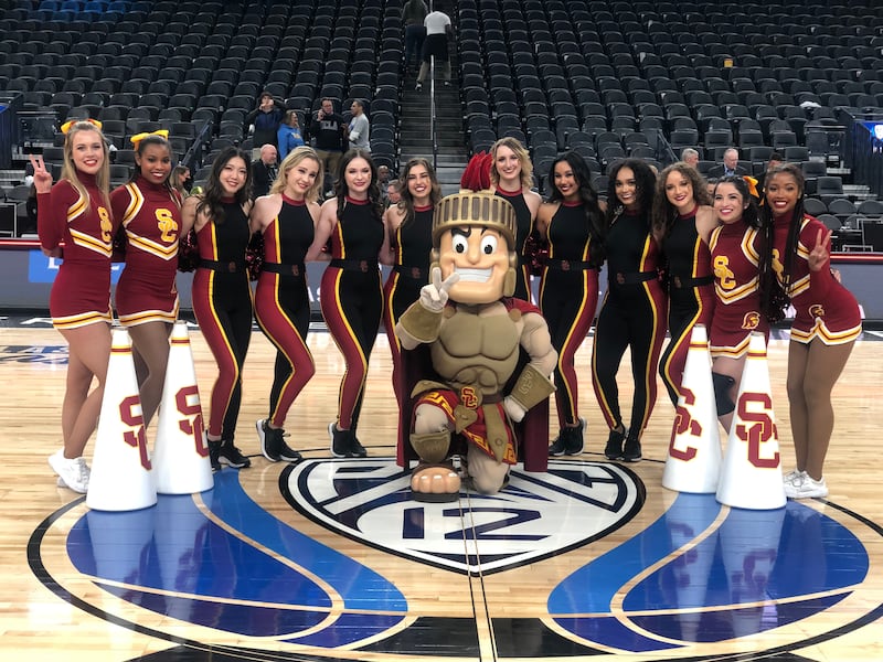 A photo of Tommy posing with the Spirit Squad and Dance Force around a halfcourt Pac-12 logo.