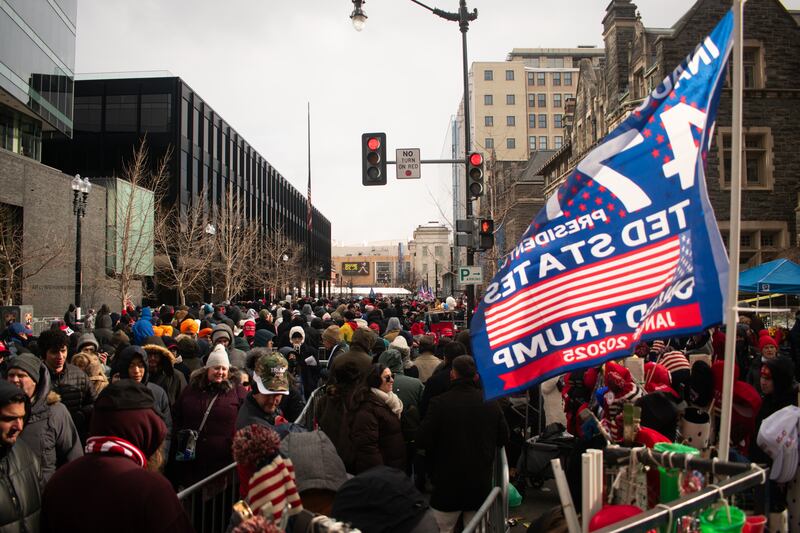 A crowd with a Trump flag above them.