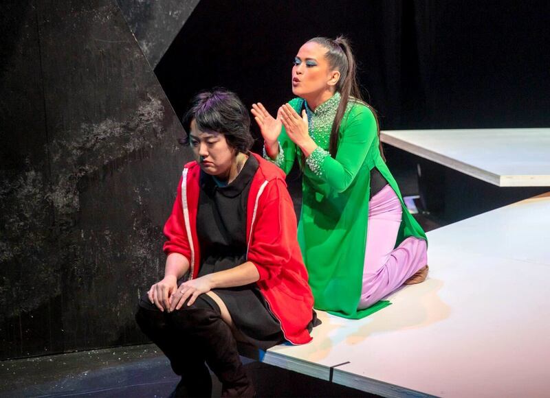 A photo of two women interacting on stage in a play.
