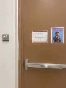 A door with a poster of Xi Jinping saying "time to go"