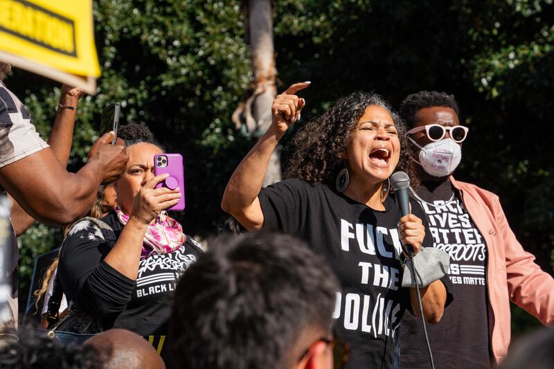 Melina Abdullah stands in the center of the crowd, passionately delivering her speech in a black t-shirt printed with "Fuck the police."