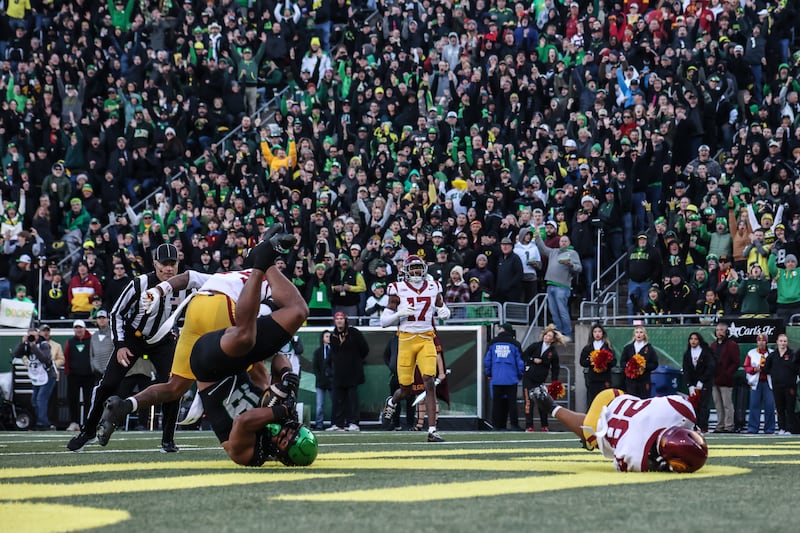 An Oregon receiver pulls in the football in the endzone despite heavy coverage from a USC defender.