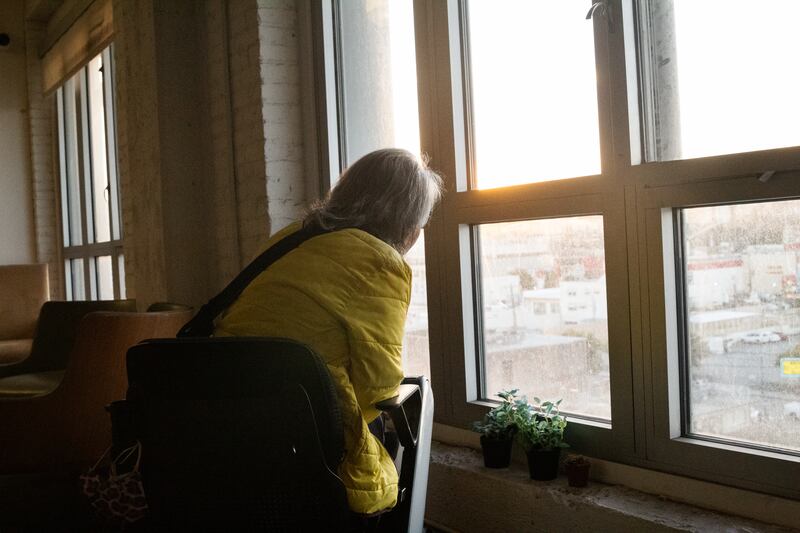 Leung-Astwood gazes towards a view of Chinatown from the window of one of the resident lounges in her apartment.