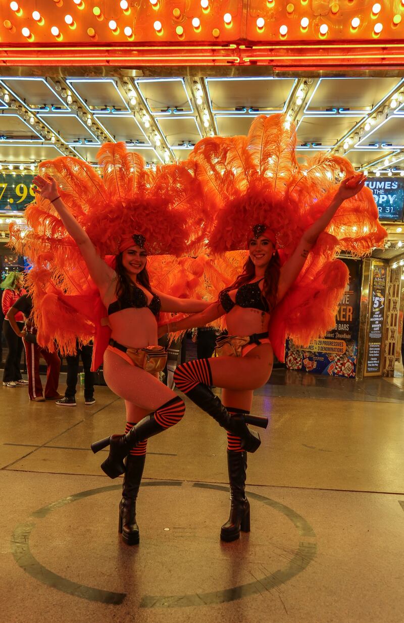 Photo of showgirls in Las Vegas posing for a picture in their feathers, bralettes, and high heel.s