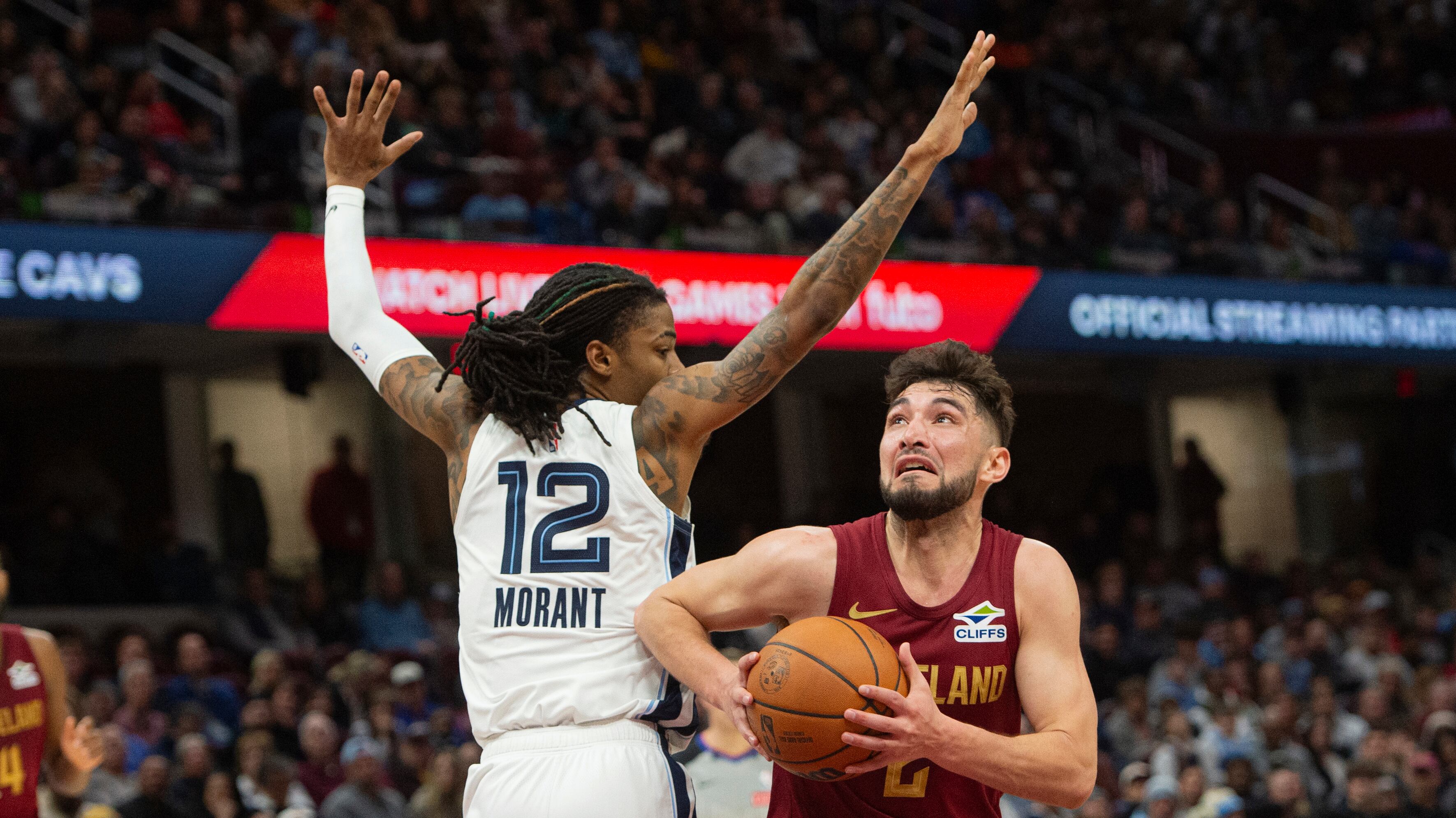 Cleveland Cavaliers' Ty Jerome, right, wearing a wine-colored number 2 jersey, drives past Memphis Grizzlies' Ja Morant (wearing number 12 in white and blue).