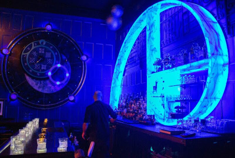 A blue bar with a bright blue Fibonacci spiral on the wall.