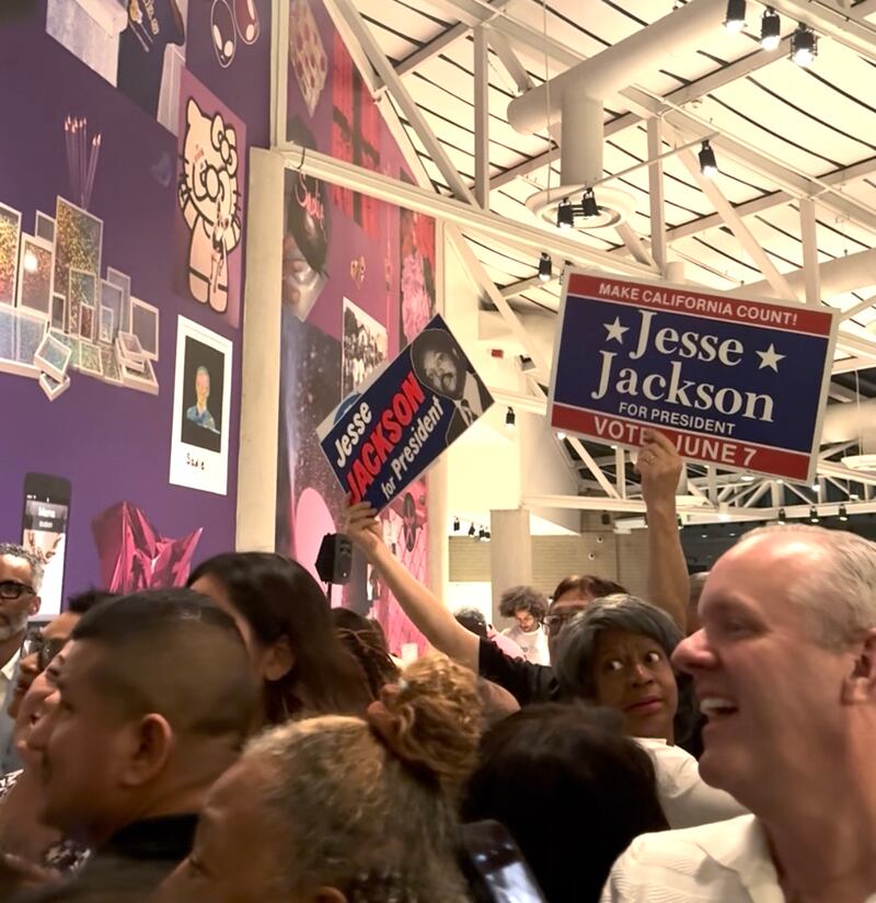An attendee waived signs from Jesse Jackson's 1988 campaign.