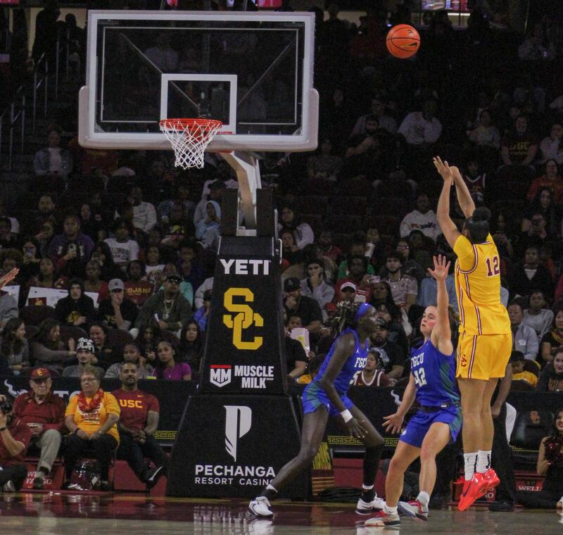 JuJu Watkins, wearing USC's gold throwbacks, is pictured putting up a shot.
