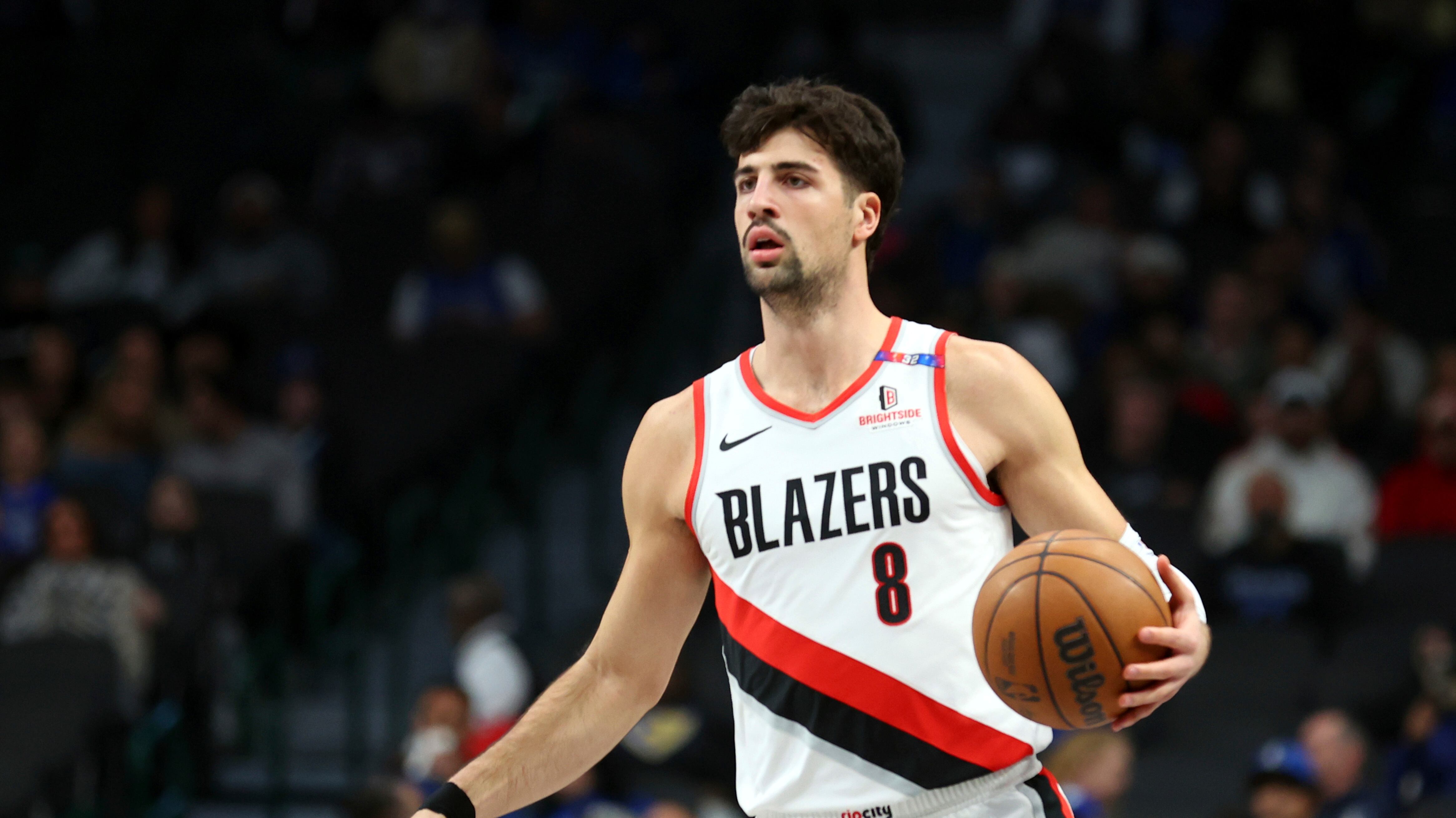 Portland Trail Blazers forward Deni Avdija (wearing number 8 in a white, red and black jersey) dribbles the ball up the court against the Dallas Mavericks in an NBA basketball game Thursday, Jan. 9, 2025, in Dallas.