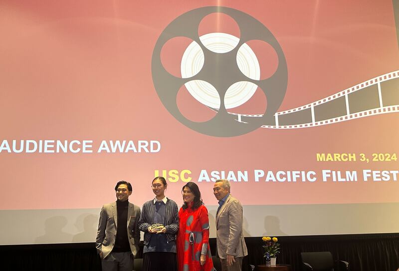 Photo of four people standing in front of a screen