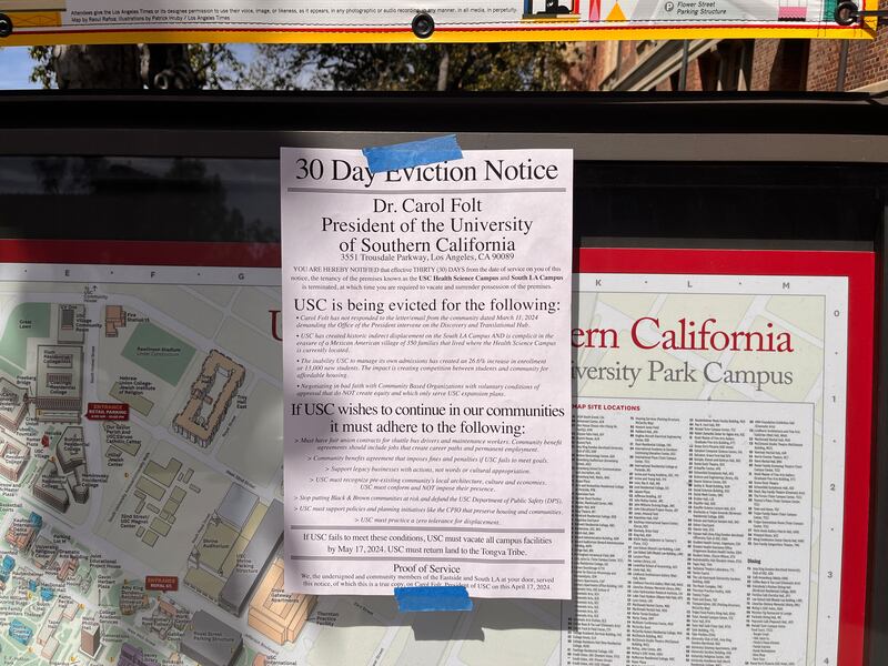 The eviction notice is taped onto a billboard with blue tape on top of a map of USC.