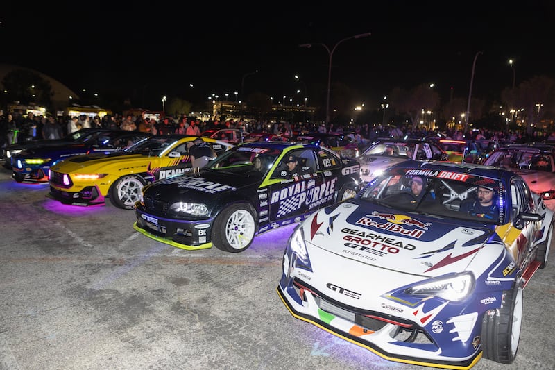 Photo of three cars with decals with lights shining out from underneath them