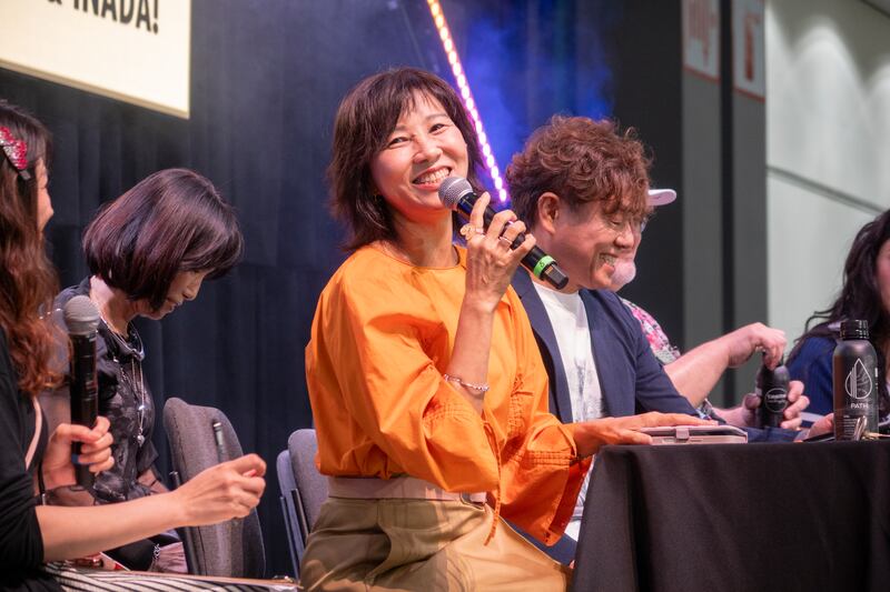 Yamaguchi smiling at the camera while on stage