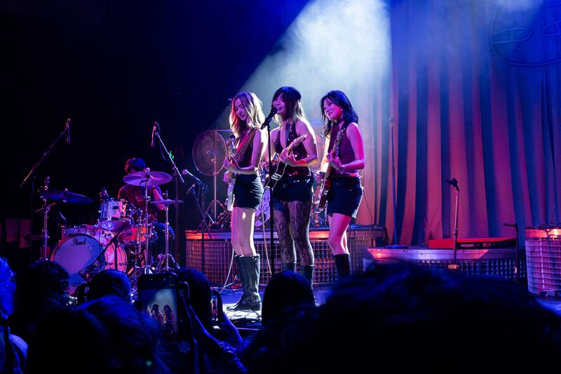 3 artists playing guitar on stage