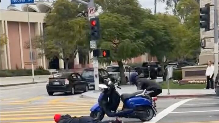 The two suspects put their hands up and laid face down in the middle of S. Hoover St. between a blue motorized scooter.
