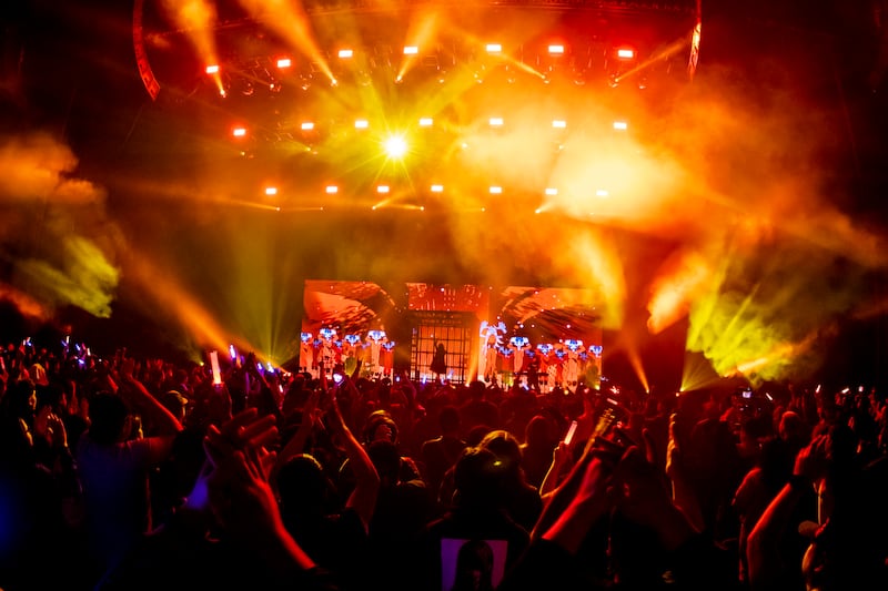 Photo of an orange stage featuring animated zombies on screen and a crowd
