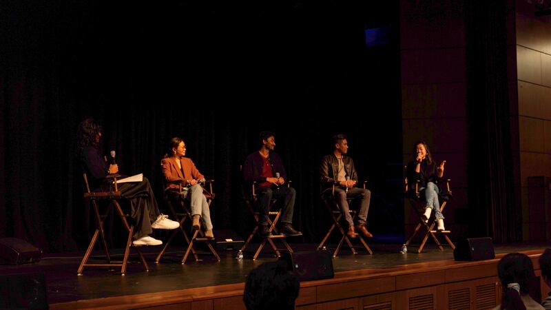 Photo of five people speaking on a stage