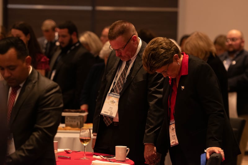 Delegates put their heads down as a prayer happens before Tim Scott's speech at the CAGOP event.
