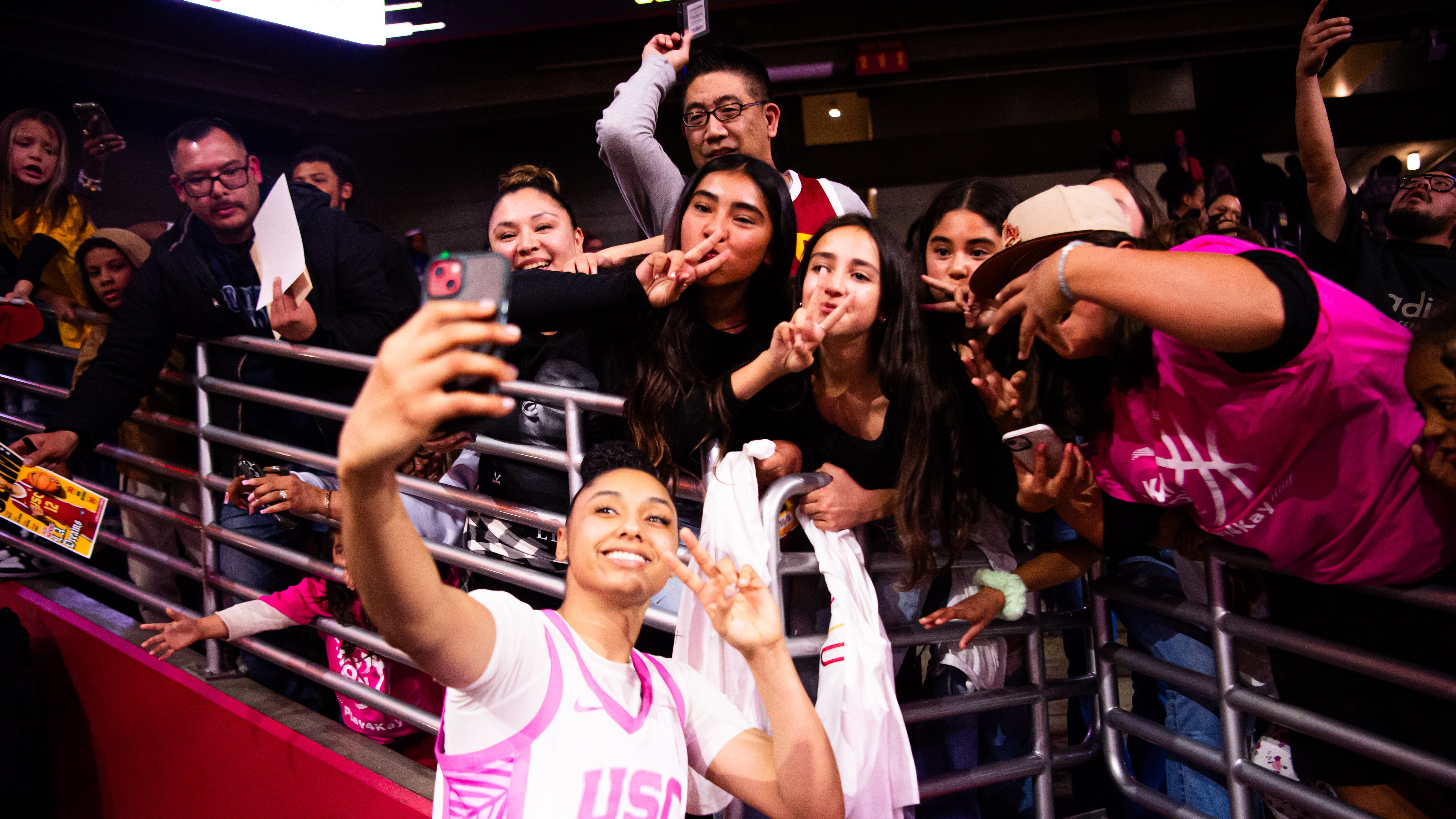 Watkins taking a selfie with fans in the stands, all putting up victory signs.
