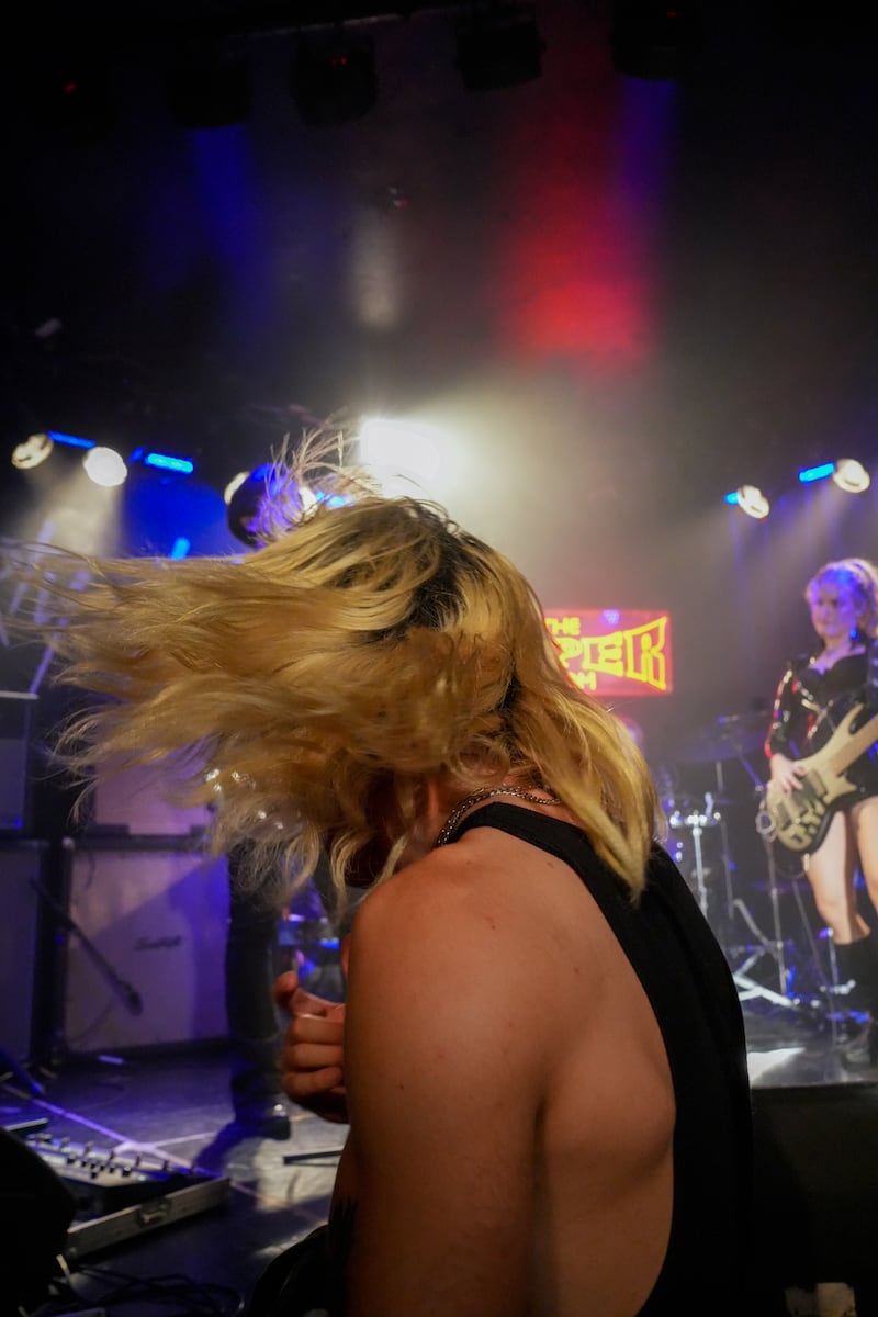 Man with blonde hair waves head.