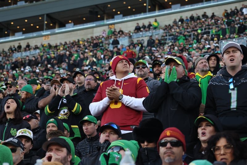 A lone USC fan clad in cardinal and gold in a sea of Oregon fans dressed in black, green and yellow.