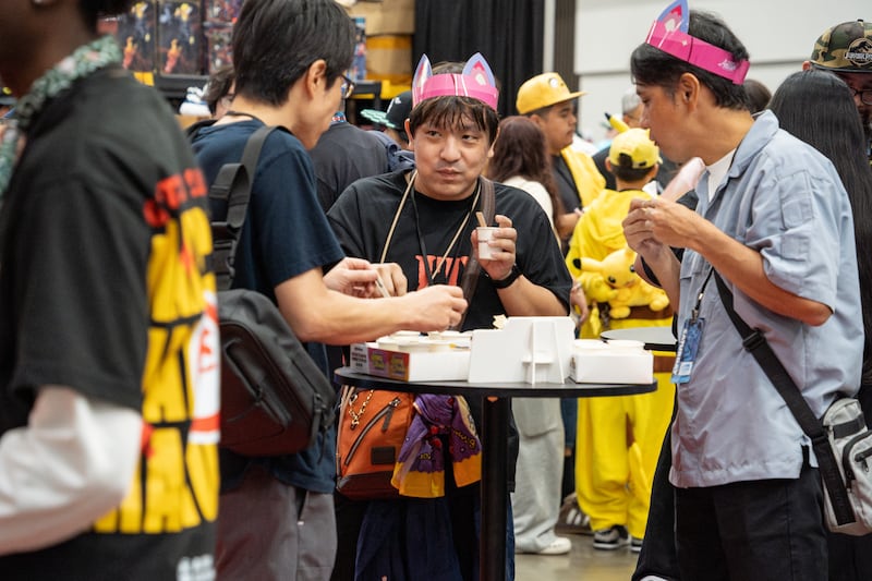 Photo of three attendees who try out samples at the Maruchan ramen bar booth.