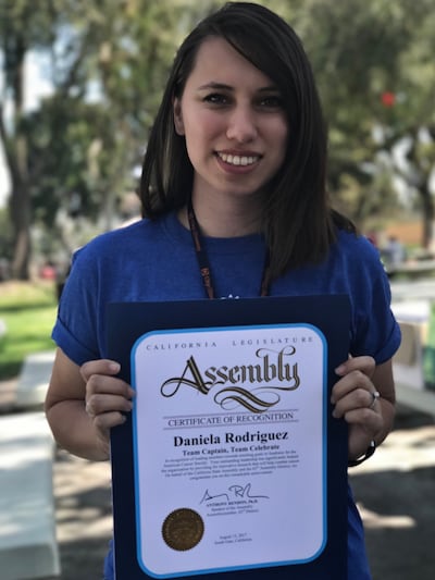Daniela holding a certificate of recognition