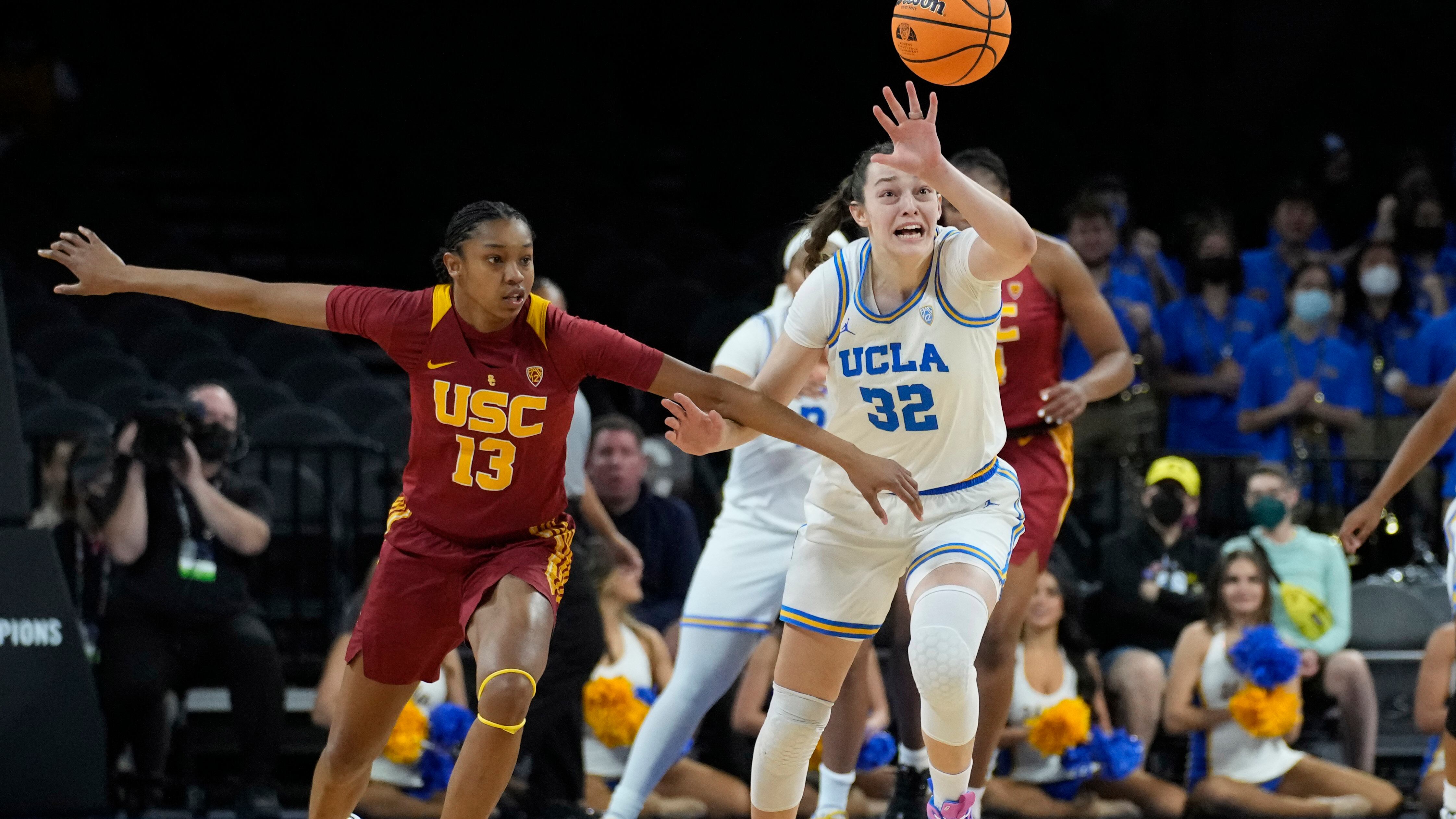 A photo of USC freshman forward Rayah Marshall in a cardinal uniform and UCLA redshirt freshman forward Angela Dugalić in a white uniform battling for a loose ball.